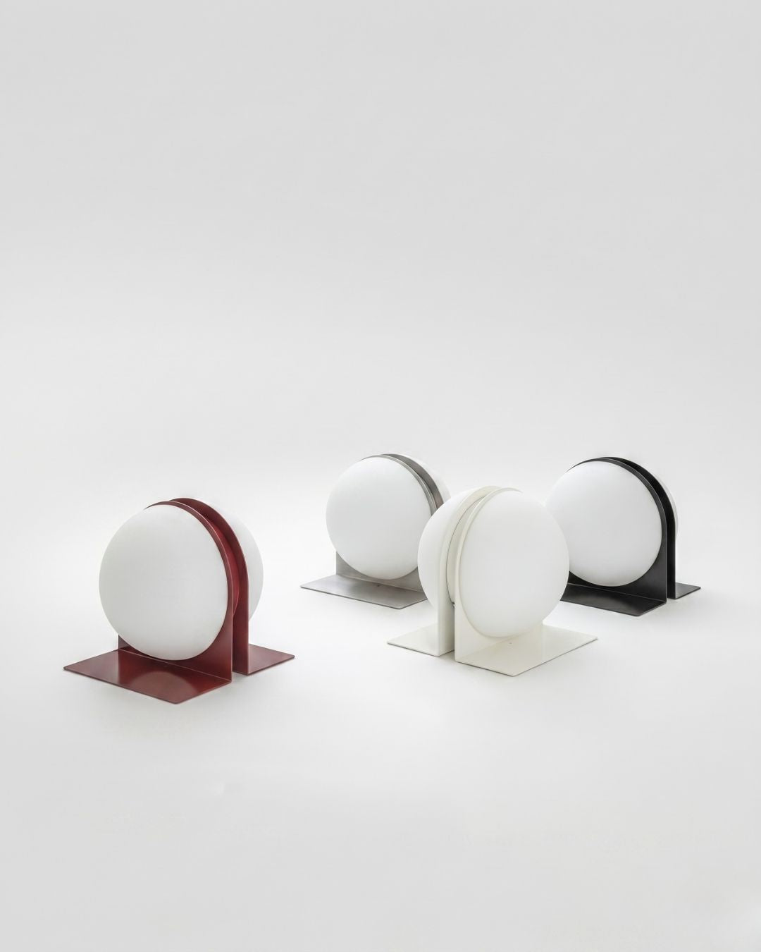 Set of four Jumelles table lamps in red, white, black and brushed aluminum, displayed together, unlit