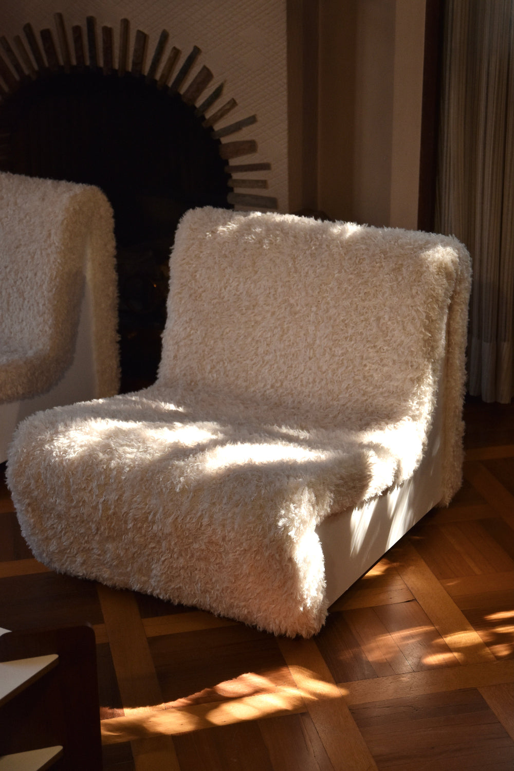 Dialogue lounge chairs by André Monpoix (1967) in Sami faux fur, in sunlight on a parquet floor