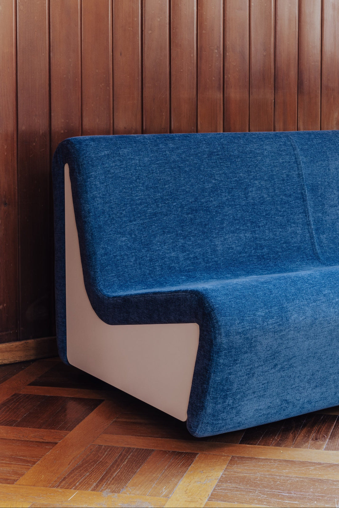 Dialogue sofa in Midnight Blue fabric with white lacquered wood side panels presented at Alcova