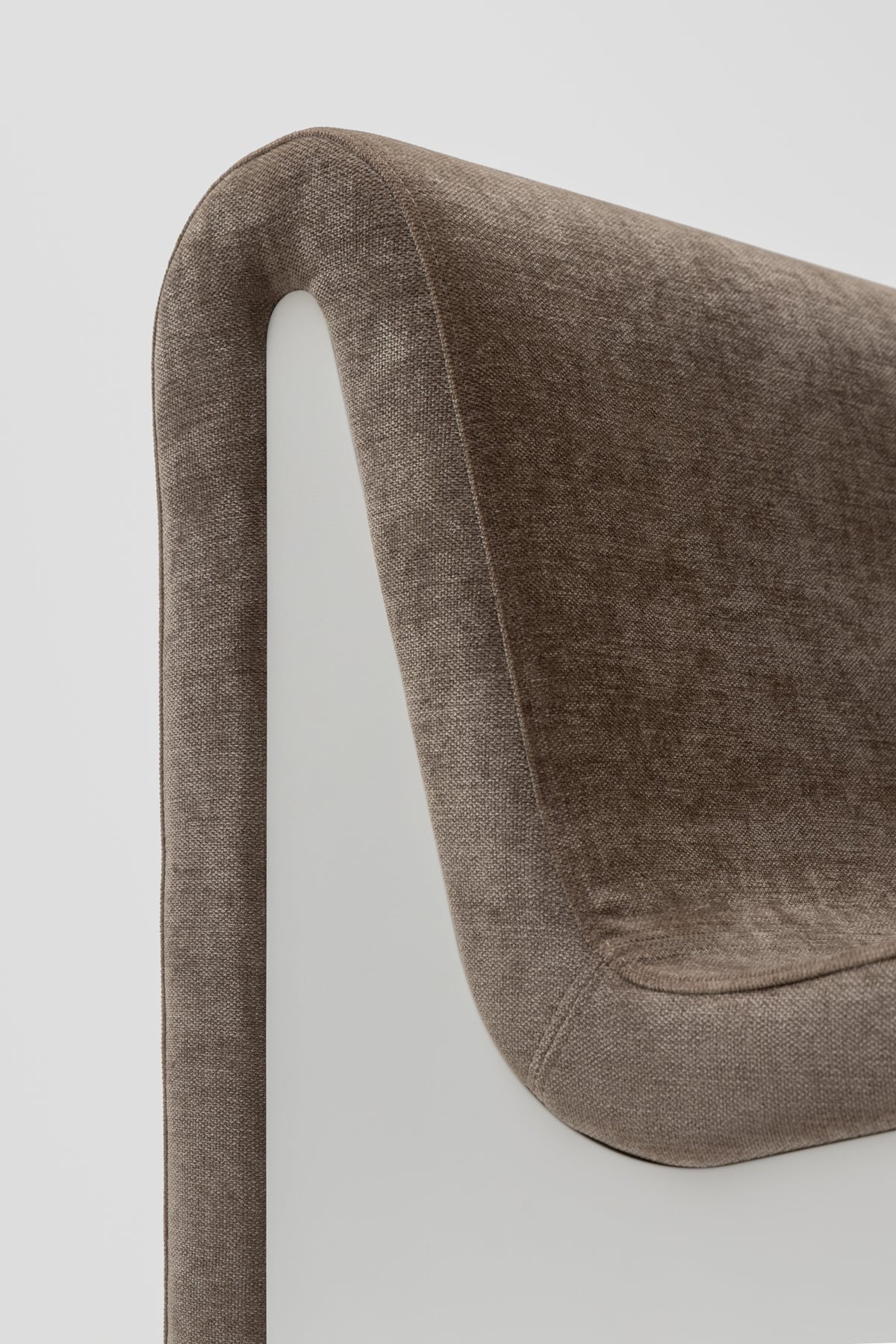 Close-up of the backrest of the Dialogue lounge chair in Clay grey fabric with white lacquered wood side panels