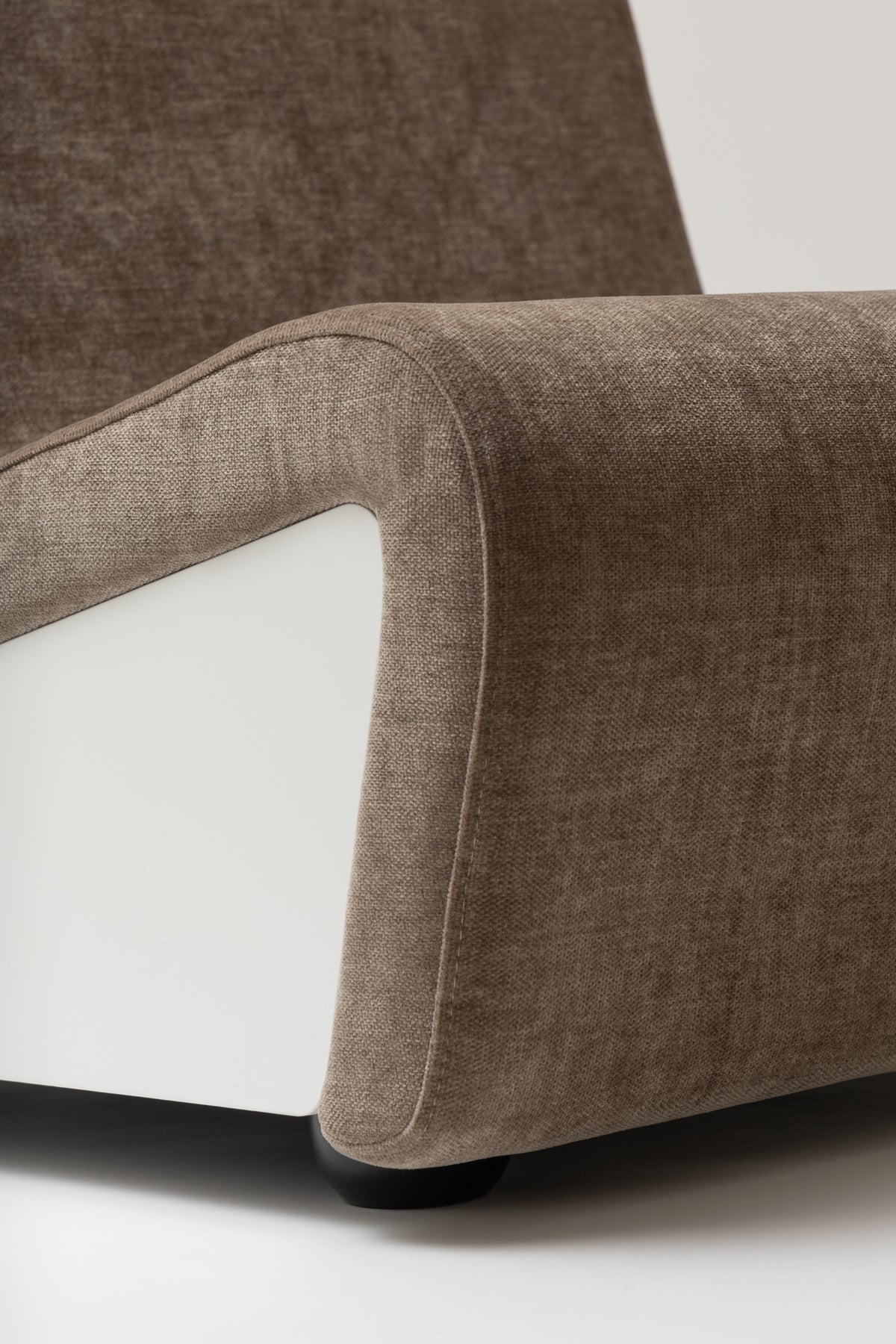 Close-up of the seat of the Dialogue lounge chair in Clay grey fabric with white lacquered wood side panels