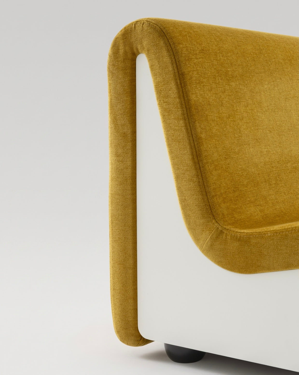 Close-up view of the Dialogue lounge chair in Amber yellow fabric and white lacquered wood side panels