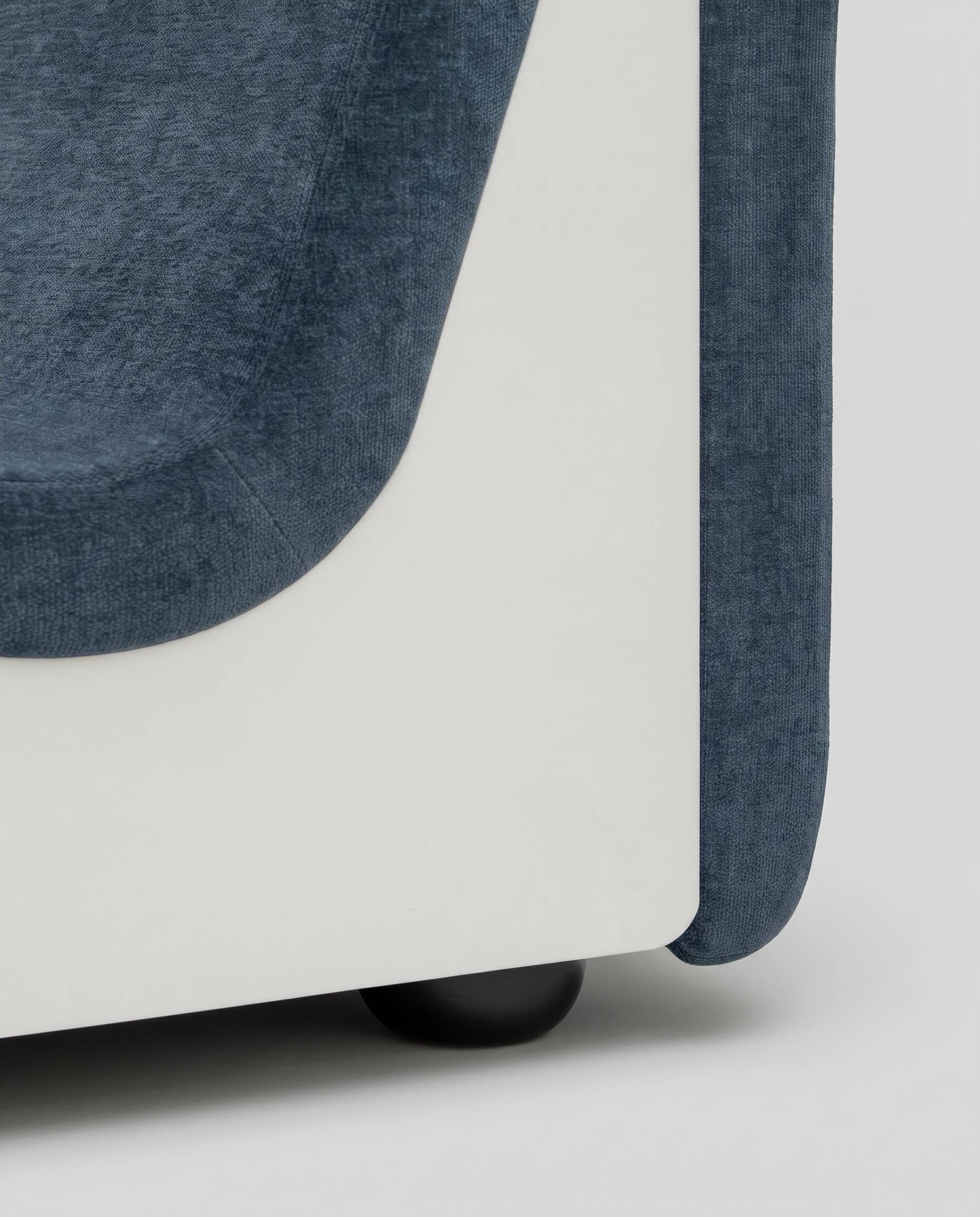 Close-up of the white lacquered wood side panel of the Dialogue sofa in Midnight Blue