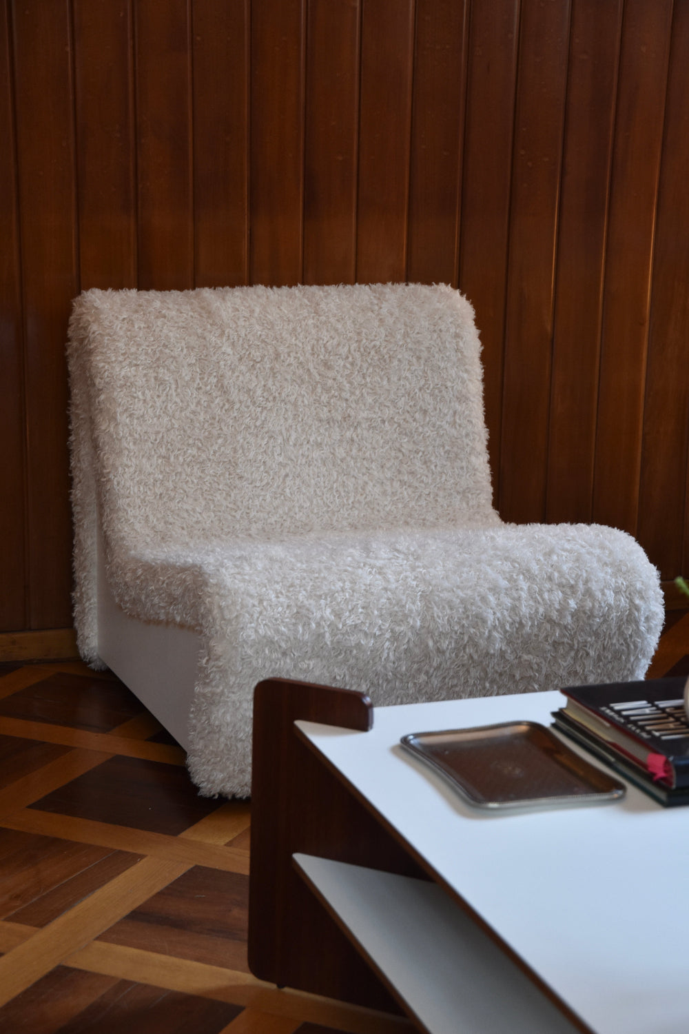 Dialogue lounge chair by André Monpoix (1967) in Sami faux fur, in a wood-panelled interior with parquet flooring