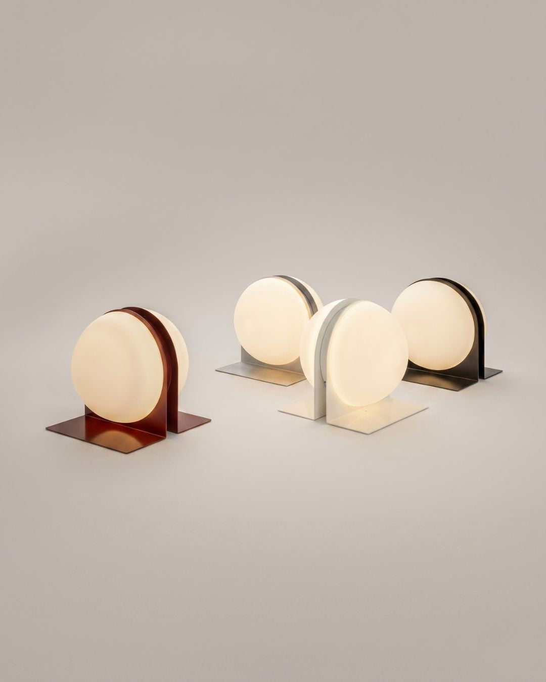 Set of four Jumelles table lamps in red, white, black and brushed aluminum, displayed together, lit
