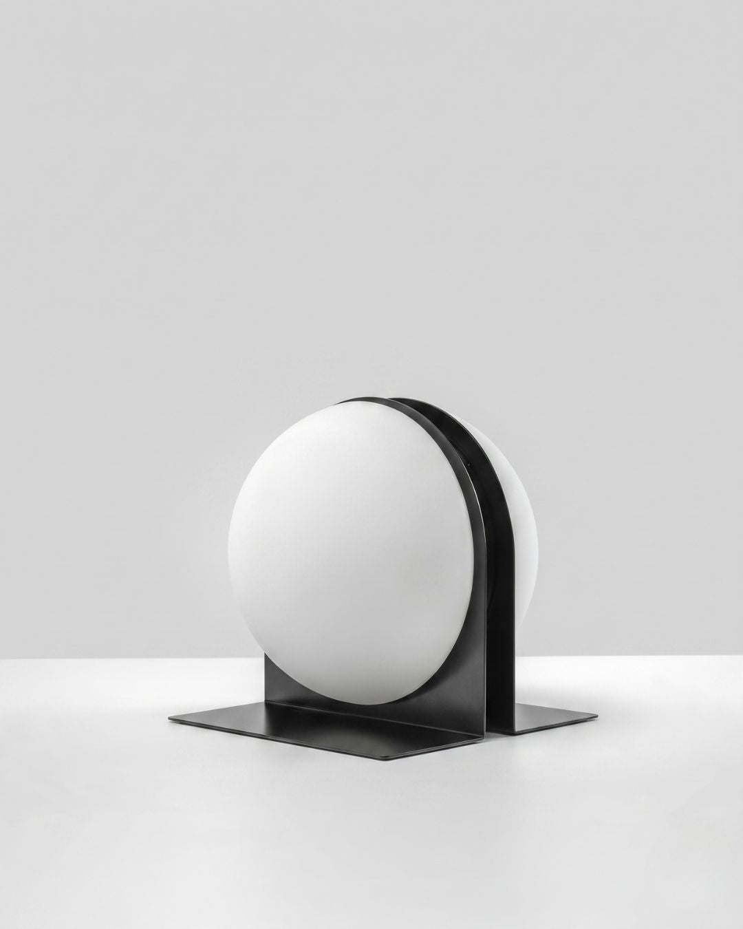 Black Jumelles table lamp, slightly angled view, lit