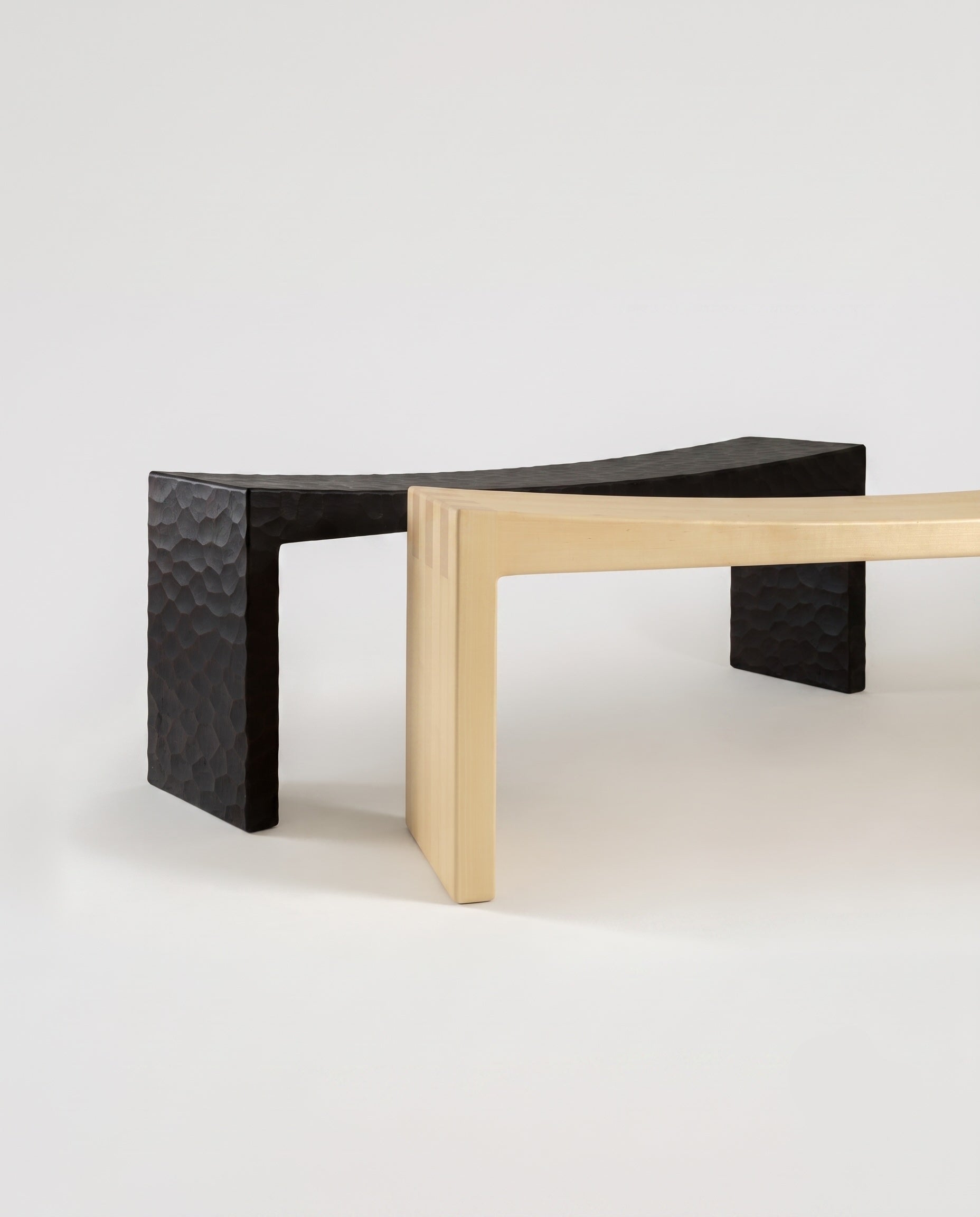 Two Basilio benches solid linden wood, one in natural smooth wood finish and one in dark gouged wood finish