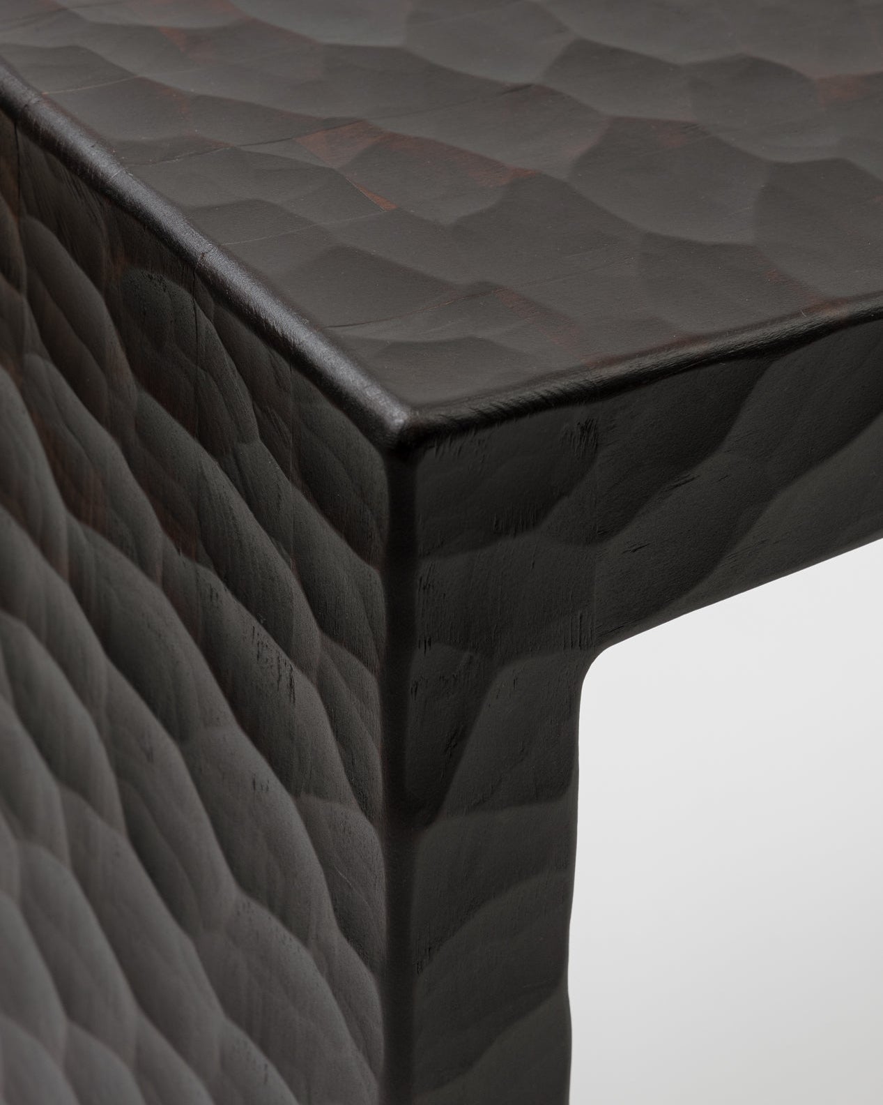 Cose-up of the Basilio stool in solid linden wood with unique dark gouged finish 