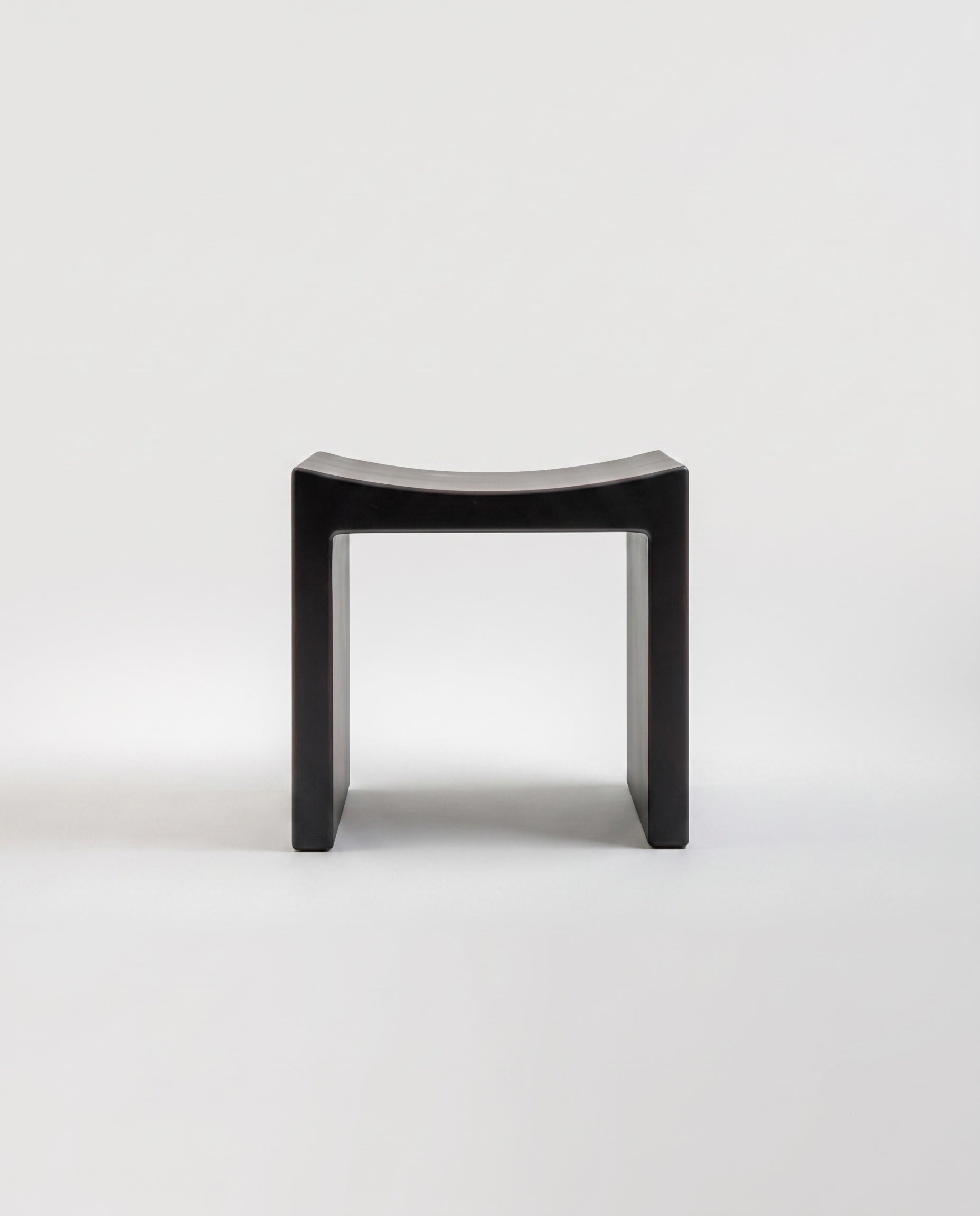 Basilio stool in solid linden with dark smooth wood finish, front view