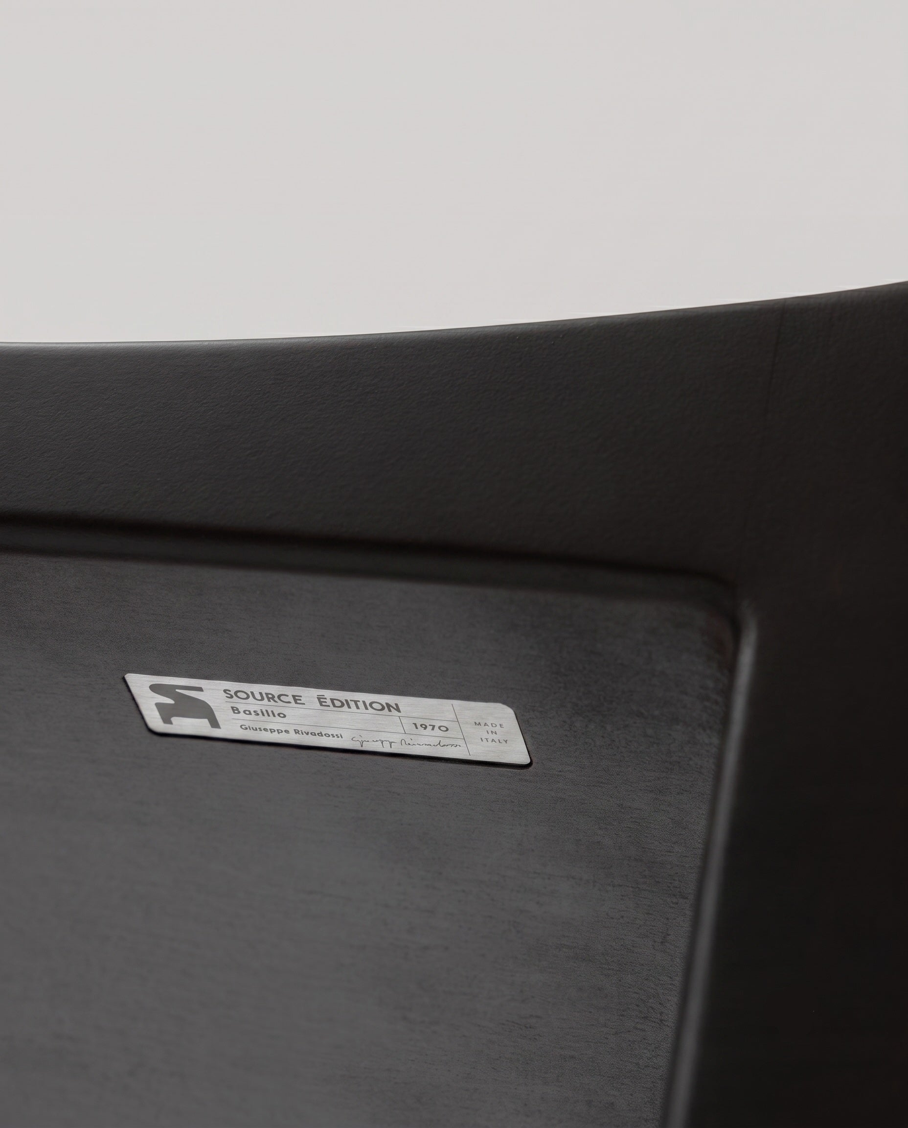 Authenticity plaque and close-up of the Basilio stool in solid linden wood with unique dark smooth finish 