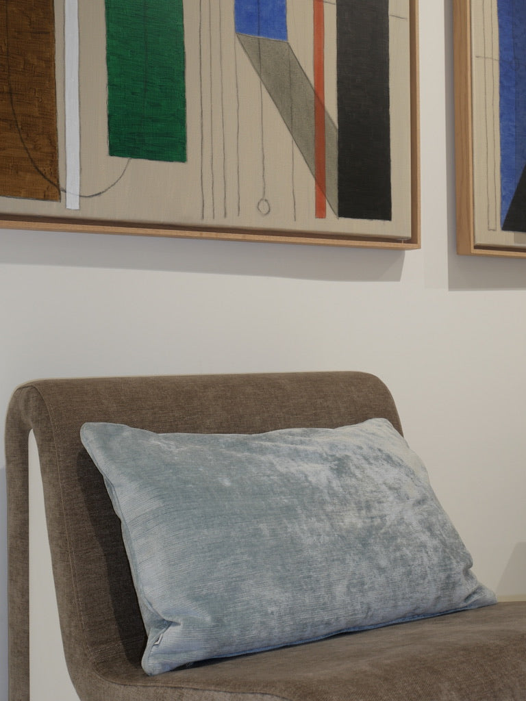 Glacier blue decorative cushion in Italian fabric, displayed on a lounge chair